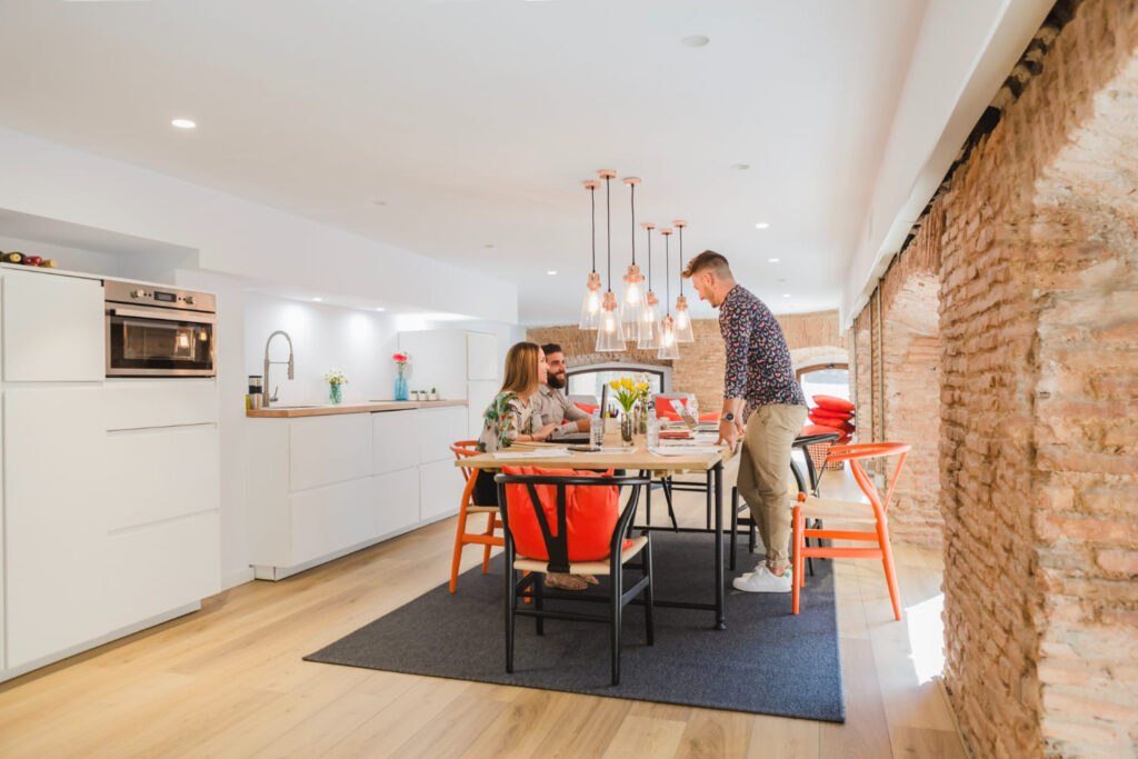 pareja joven disfrutando de desayuno en cocina moderna con pared de ladrillo expuesta